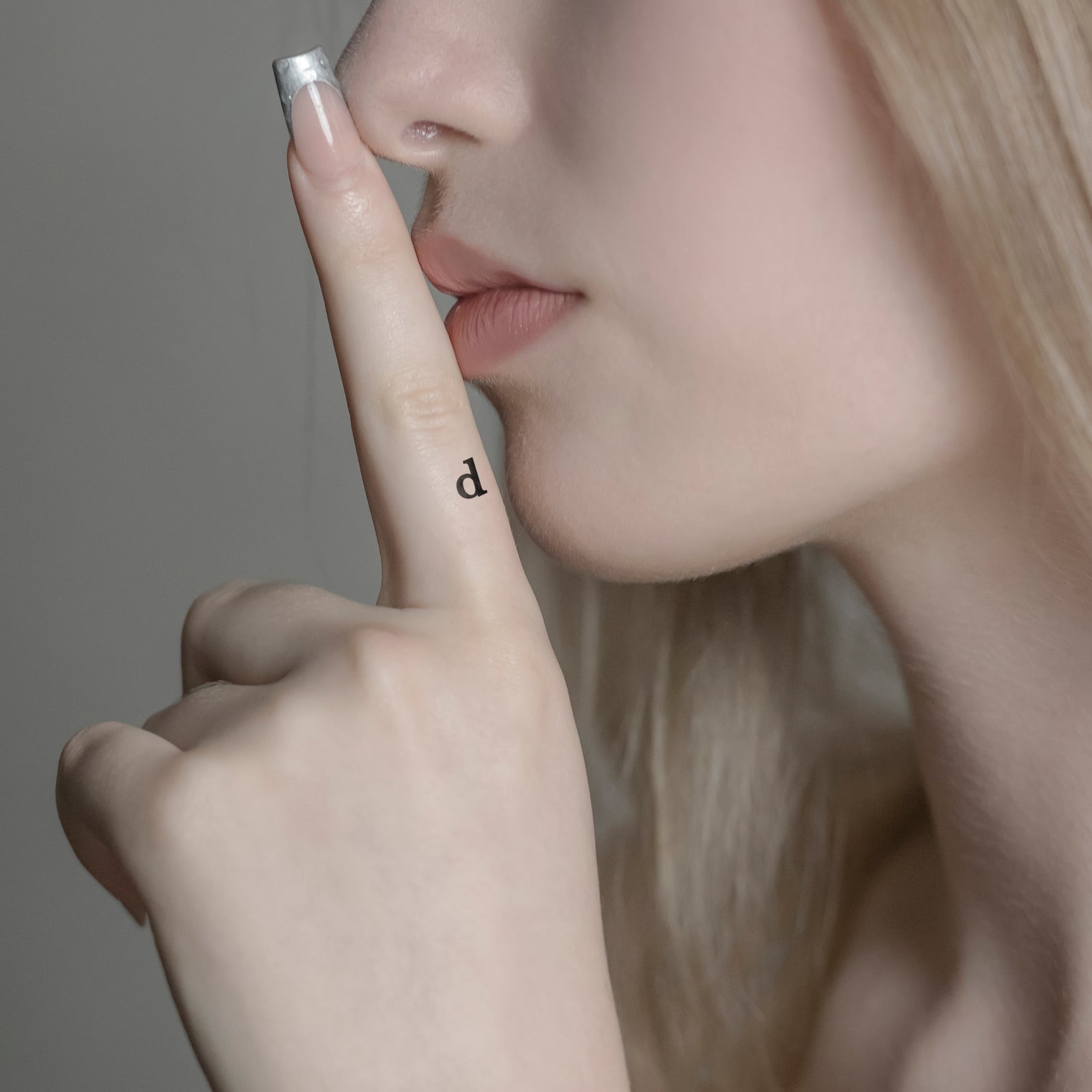 Schriftzug Tattoo Kleinbuchstabe: d von minink, der Marke für temporäre Tattoos.