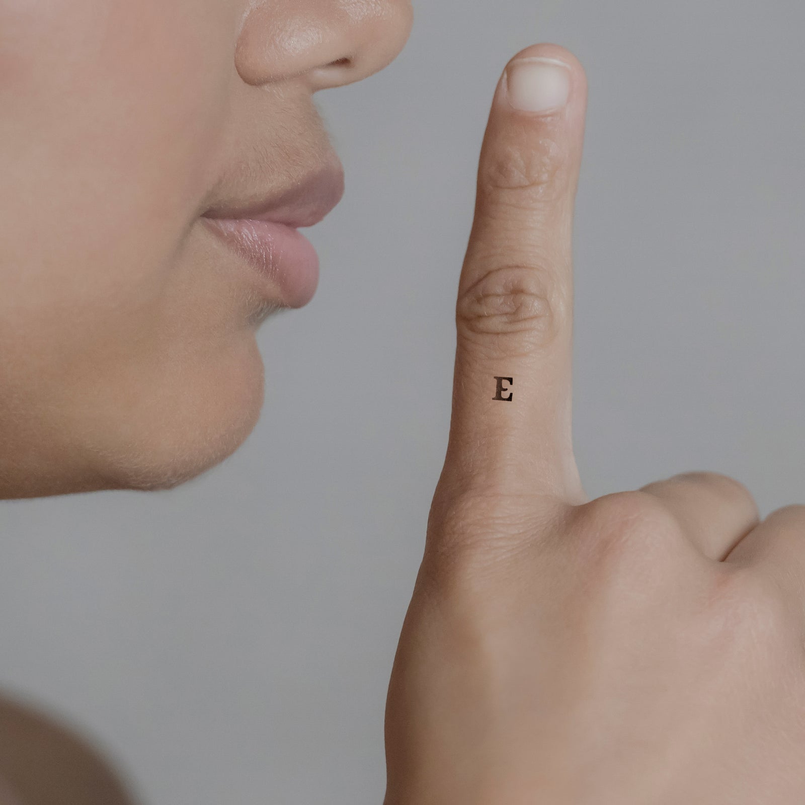 Schriftzug Tattoo Grossbuchstabe: E von minink, der Marke für temporäre Tattoos.