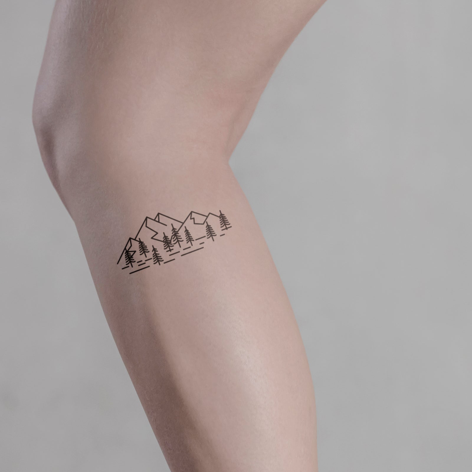 Berge und Bäume Tattoo von minink, der Marke für temporäre Tattoos.