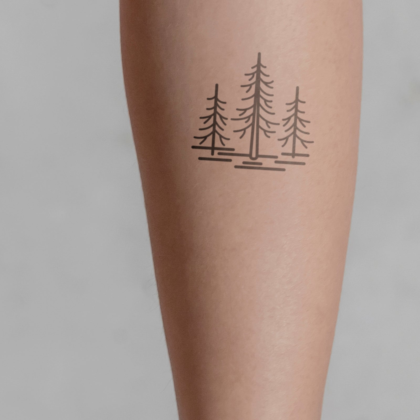 Drei Tannen Tattoo von minink, der Marke für temporäre Tattoos.