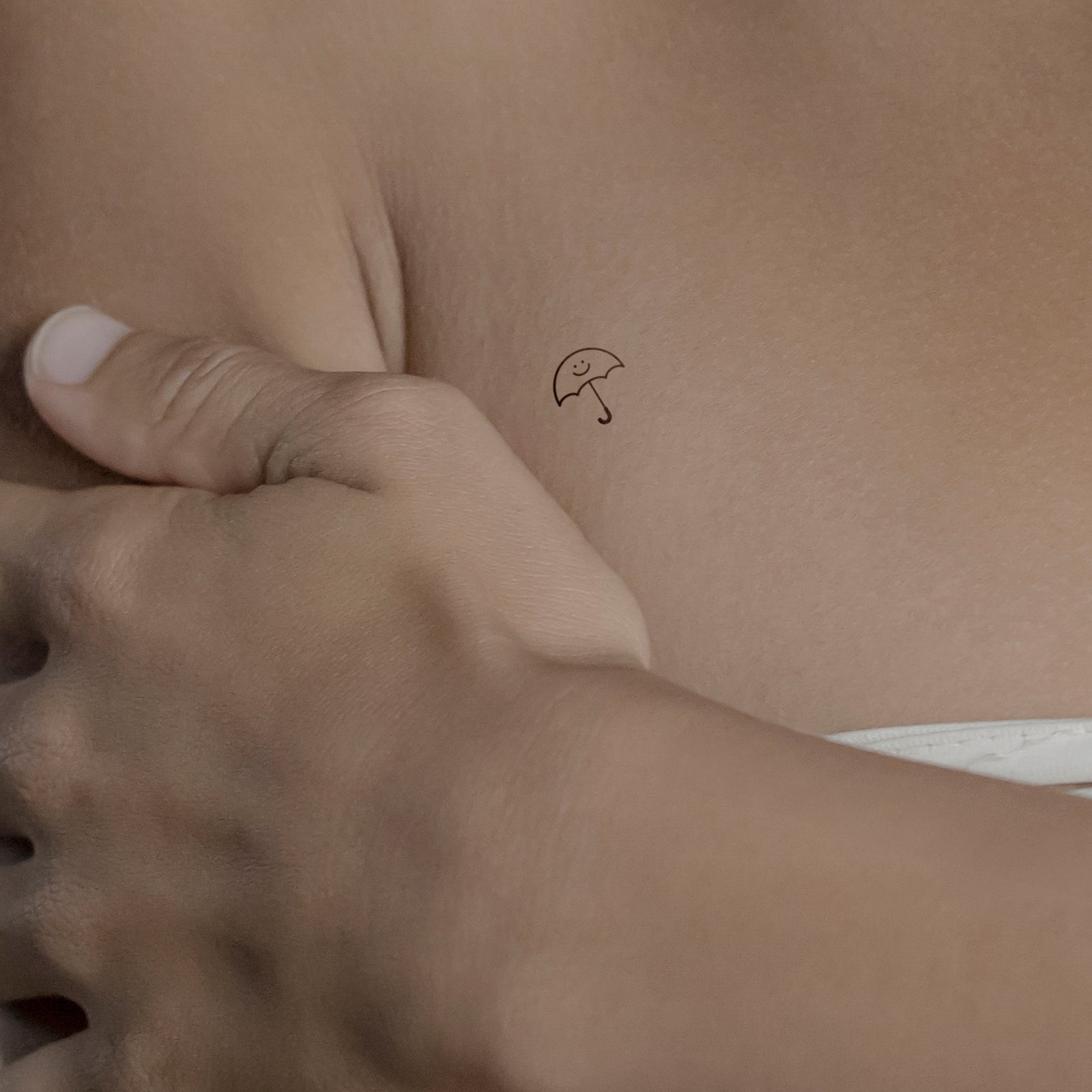 Lächelnder Schirm Tattoo von minink, der Marke für temporäre Tattoos.