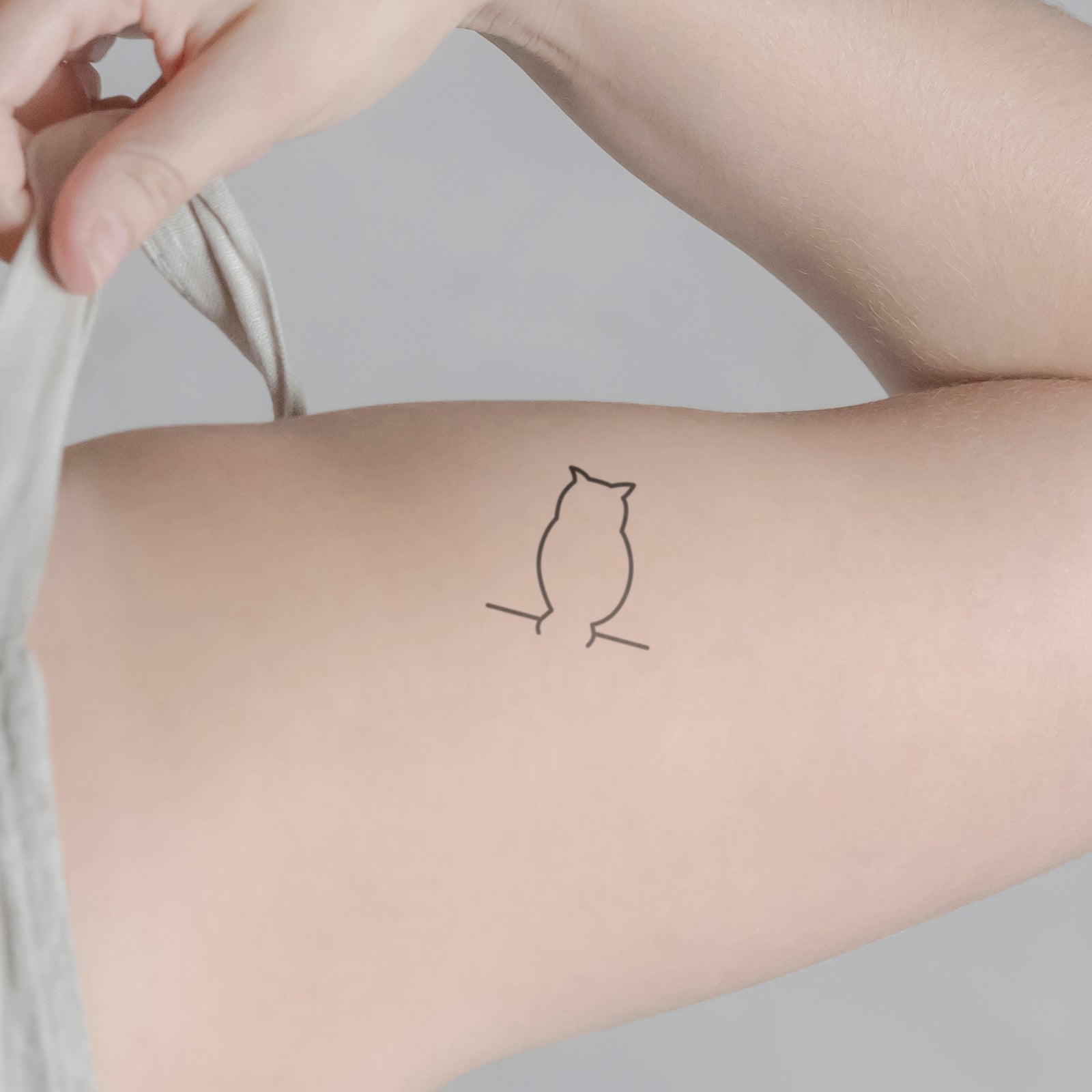 Minimalistische Eule Tattoo von minink, der Marke für temporäre Tattoos.